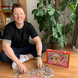 Person doing a jigsaw of a pink dog